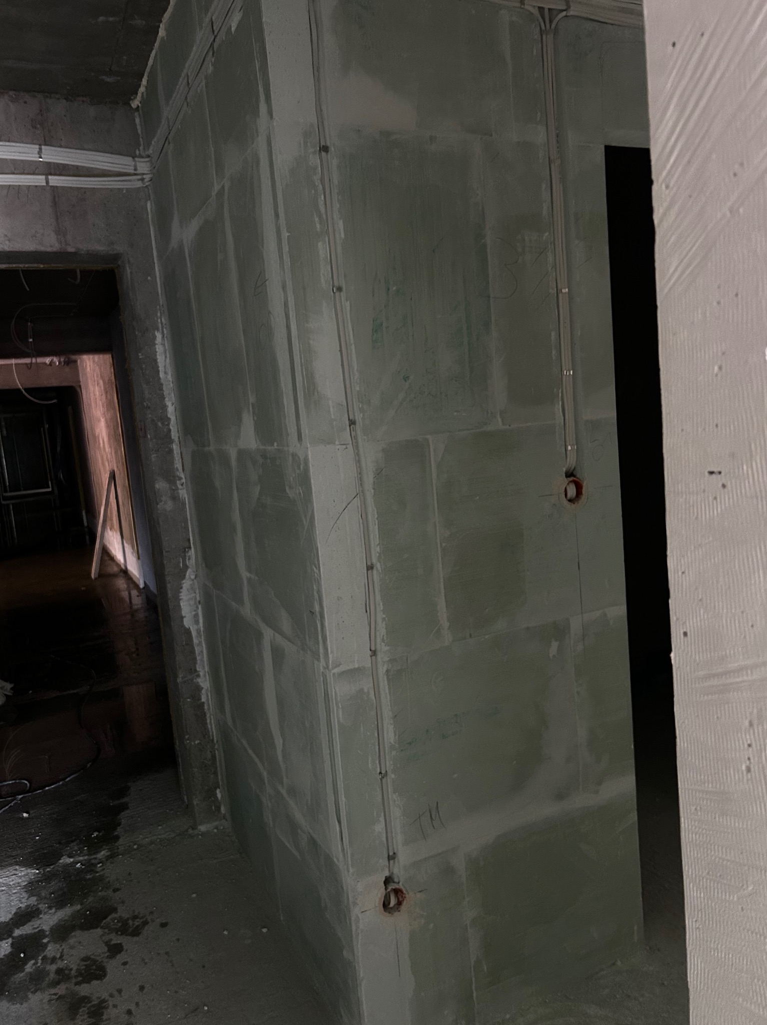 Ściana z instalacją elektryczną w trakcie montażu, widoczne kable i puszki. Prace w nowym budynku w Gdańsku.