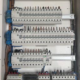 Nobisend - Rozdzielnica elektryczna z zainstalowanymi bezpiecznikami i przewodami, widok z bliska. Elementy Eaton. Instalacja w białej obudowie.