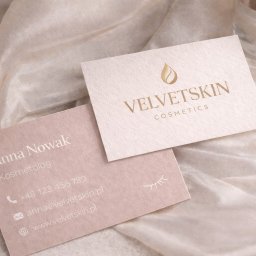 Shinedesing Klaudia Pikulik - Dwie wizytówki na jedwabnej tkaninie: jedna z logo 'VelvetSkin Cosmetics', druga z danymi kontaktowymi Anny Nowak, kosmetolog. Subtelna kolorystyka, minimalistyczny design.