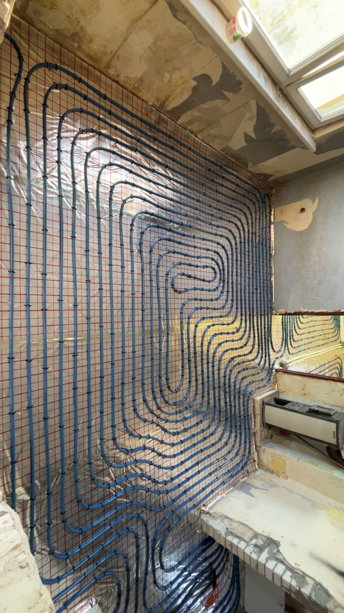 Instalacja ogrzewania podłogowego na ścianie, rury w kształcie meandru, siatka montażowa, folia izolacyjna. Prace hydrauliczne w Nowym Tomyślu.