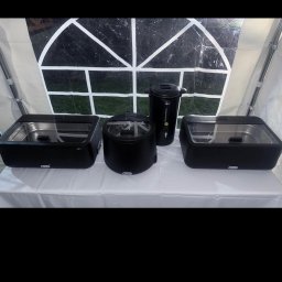 PleneroVo Events - Czarny sprzęt gastronomiczny Hendi: bemar, podgrzewacz do zupy i dozownik napojów na białym obrusie w namiocie. Widok z przodu, oświetlenie naturalne.