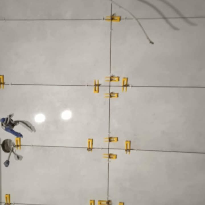 Ułożone płytki z żółtymi krzyżykami dystansowymi, widoczne linie fug i narzędzie do układania płytek. Jasne, jednolite tło płytek.