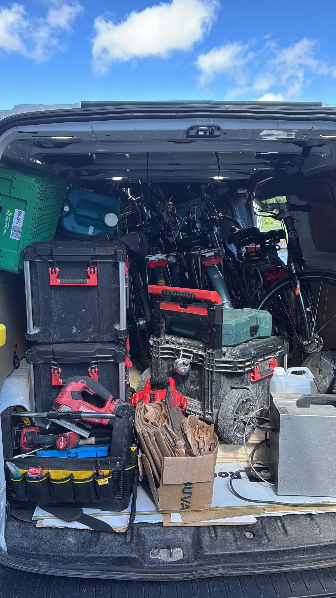 Wnętrze busa serwisowego w Świedziebni, wypełnione narzędziami, skrzynkami i rowerami, sugerujące mobilny serwis lub transport.