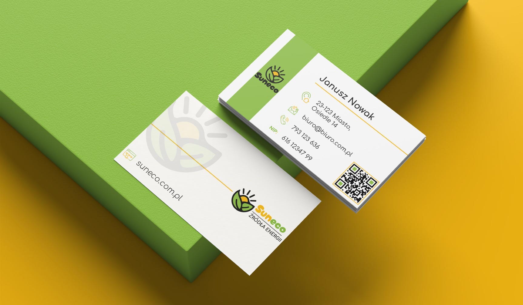 Dwie wizytówki firmy Suneco z zielonym logo na białym tle, leżące na zielono-żółtym tle. Jedna wizytówka z danymi kontaktowymi, druga z adresem strony internetowej.