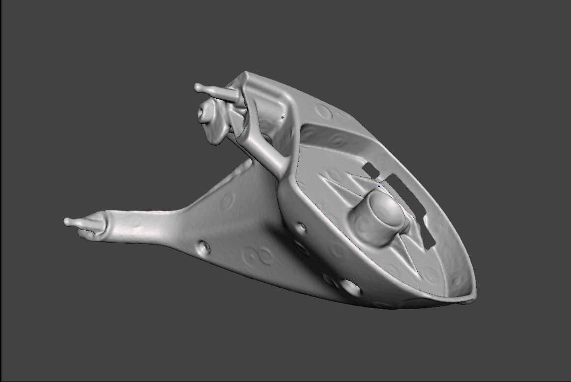 Szary model 3D części samochodowej z widocznymi otworami i wypustkami, prezentowany na jednolitym, ciemnym tle. Model wydaje się być prototypem lub wizualizacją.