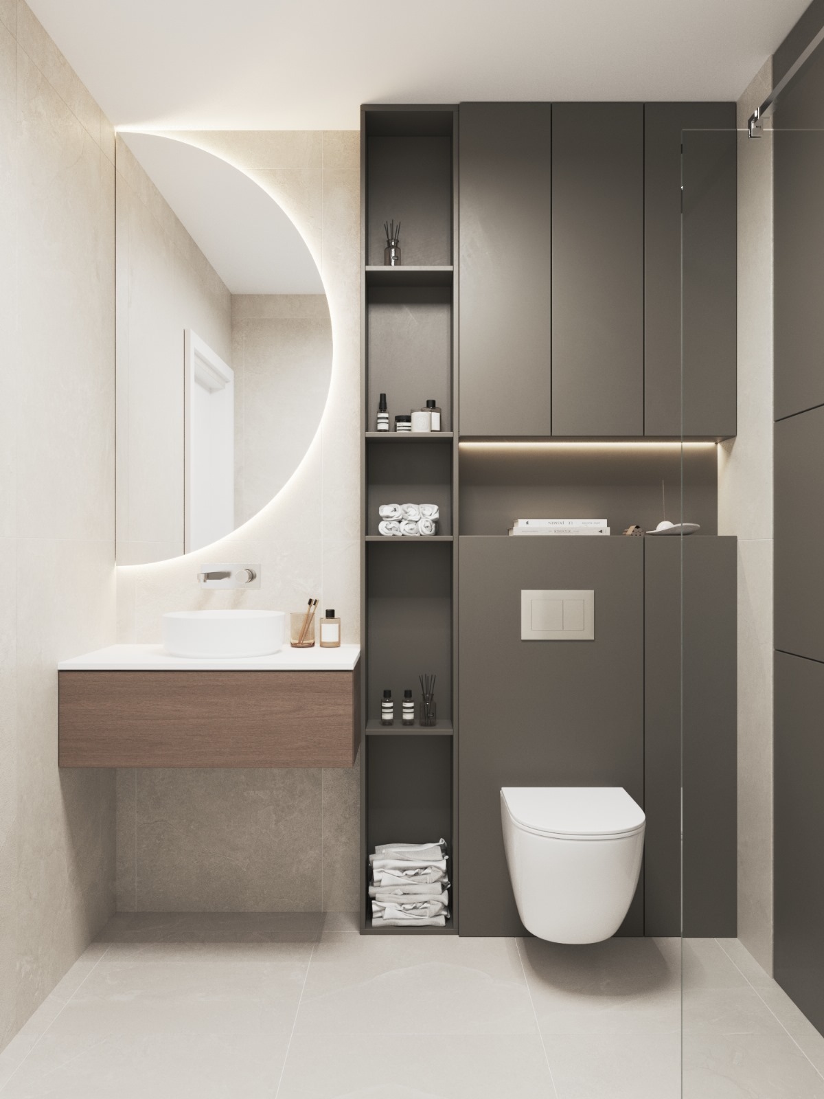 Nowoczesna łazienka z okrągłym lustrem podświetlanym LED, wiszącą szafką z drewnianym frontem i zabudową z szarymi szafkami oraz toaletą. Minimalistyczny design.