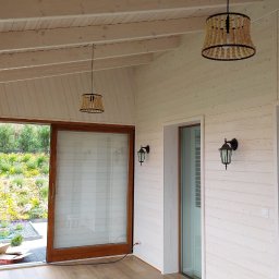 Sneker - Jasne, drewniane wnętrze z dużymi oknami przesuwnymi, przez które widać kwitnący ogród. Dwa ozdobne żyrandole i kinkiety dodają przytulnego charakteru.