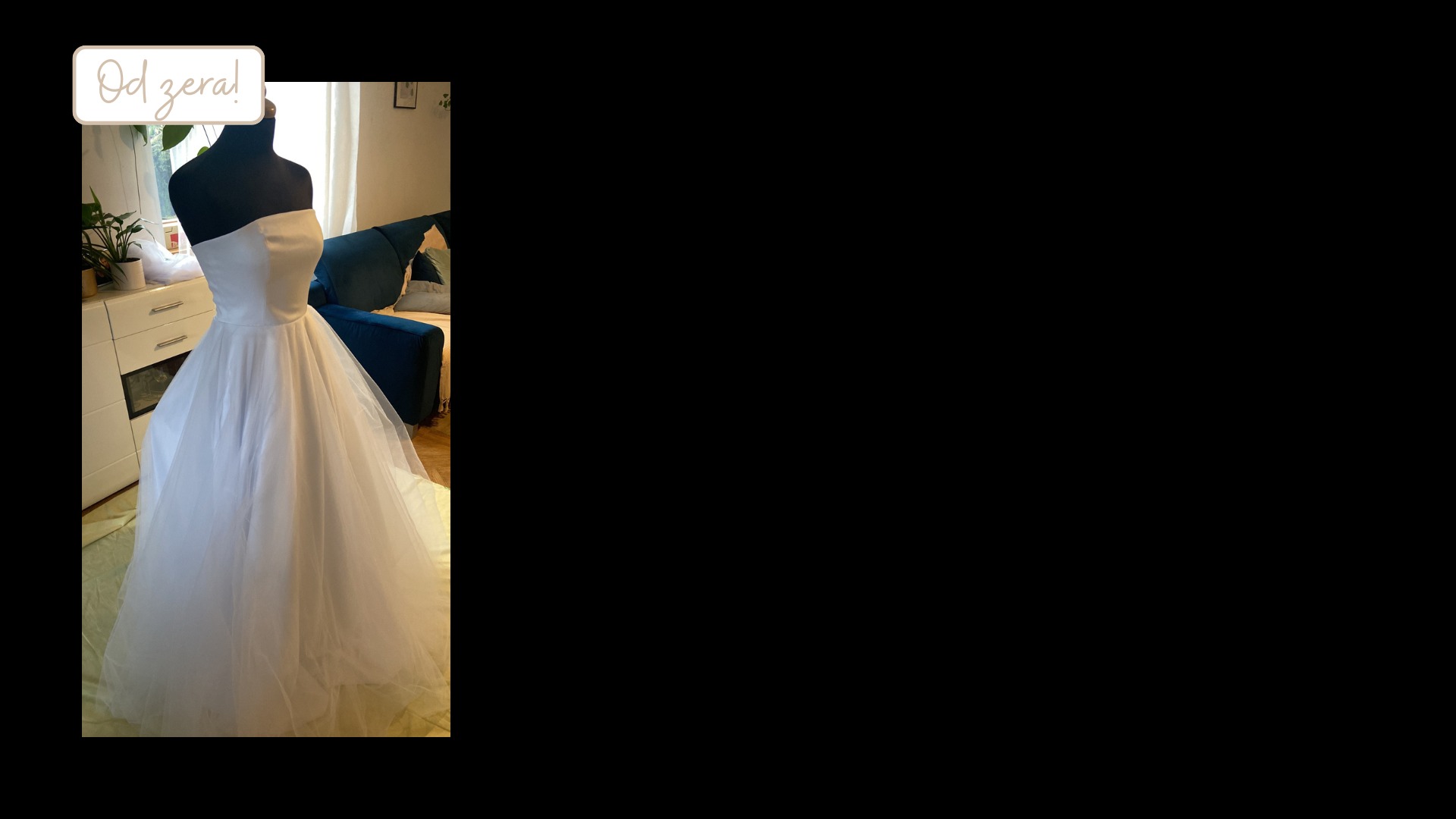 Biała suknia ślubna na czarnym manekinie krawieckim, z napisem 'Od zera!' w rogu, w tle meble w salonie. Suknia z tiulowym dołem i gładką górą.