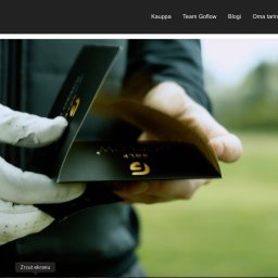 Ecosta global - Dłoń w białej rękawicy golfowej prezentuje czarne opakowanie z logo GoFlow Golf na tle zielonego pola golfowego. Opakowanie ma złote akcenty.