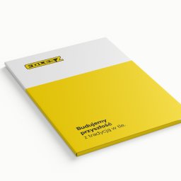 Katarzyna Rębacz - Biało-żółta broszura z logo i hasłem 'Budujemy przyszłość z tradycją w tle' leżąca na białym tle, prezentowana pod kątem.