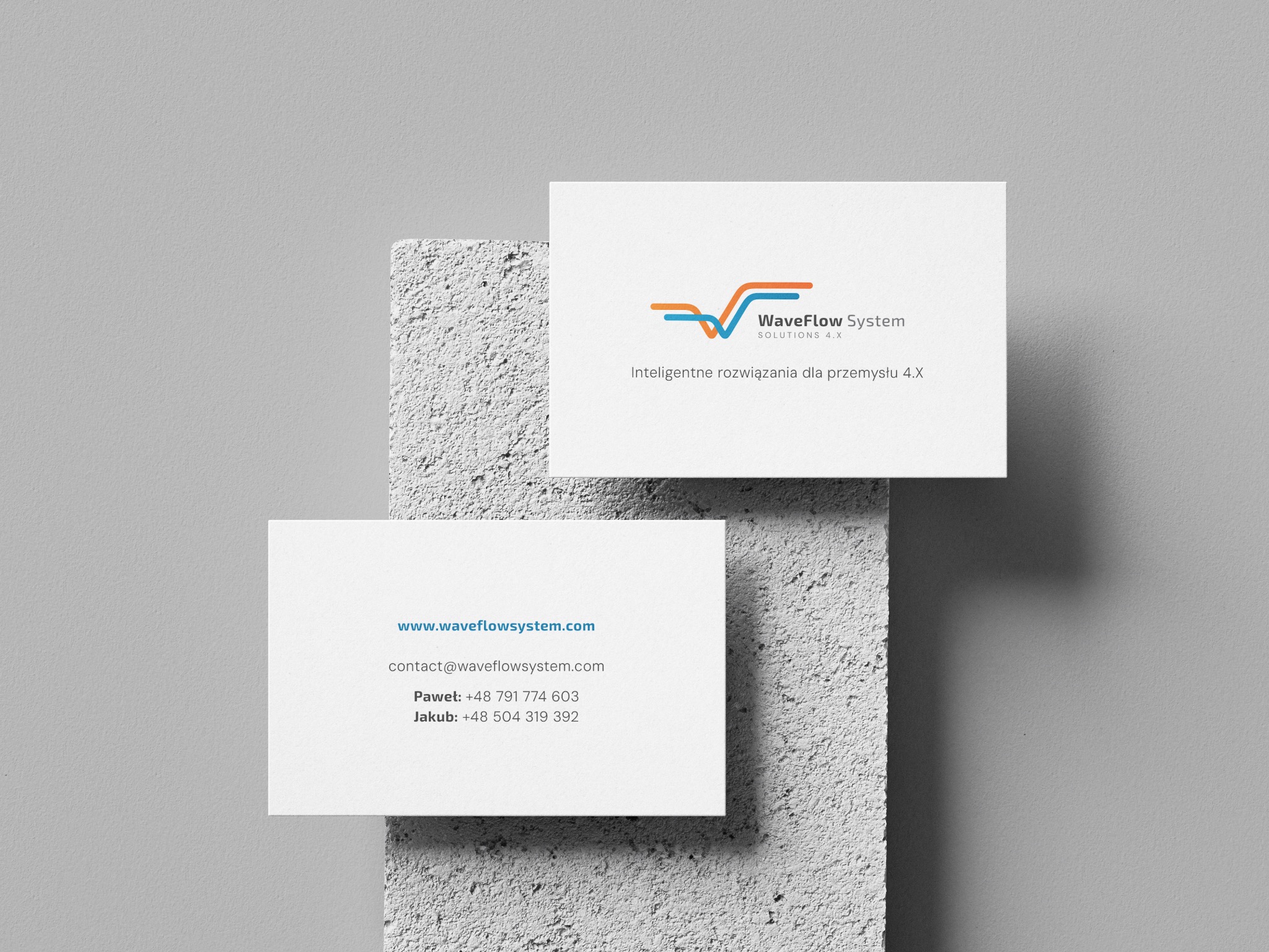 Dwie wizytówki WaveFlow System z logo (niebiesko-pomarańczowe fale) na teksturowanym, szarym tle. Minimalistyczny design, nowoczesna typografia, kontakt do Pawła i Jakuba.