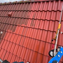 Mazo Wash Krystian Balcerzak - Częściowo umyty, czerwony dach z dachówki karpiówki. Widoczna lina asekuracyjna i fragment narzędzia do czyszczenia. Porównanie stanu przed i po.
