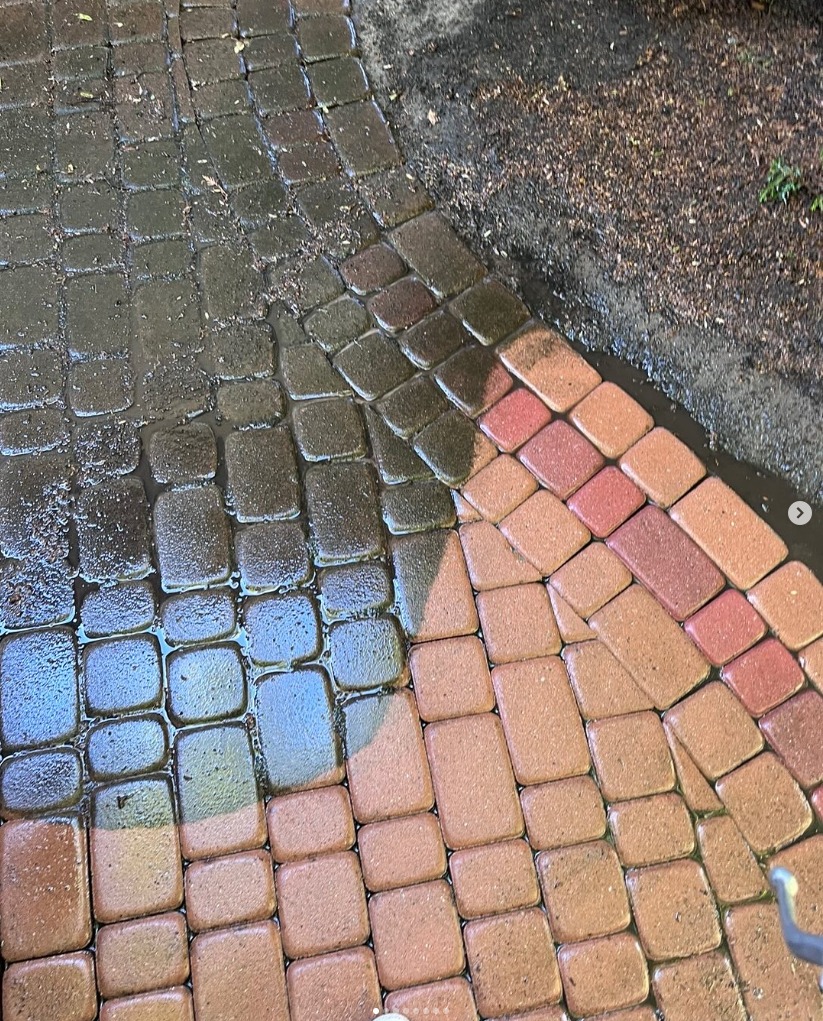 Częściowo umyta kostka brukowa w odcieniach czerwieni i brązu, widoczna różnica w czystości między umytą a zabrudzoną powierzchnią.