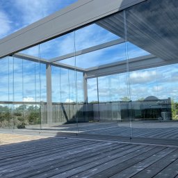 Pergola z rozwijanym dachem tkaninowym wraz z bezramowym systemem przesuwnym