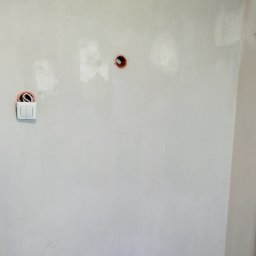 TOMASZ PIETRUCZANIS ELTECH SERWIS - Ściana po szpachlowaniu z zamontowanym, podwójnym włącznikiem światła i puszkami elektrycznymi. Widoczne przewody.