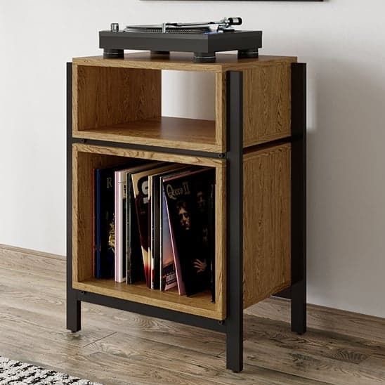 Regał na płyty winylowe z gramofonem na górze, drewniane półki w metalowej ramie, widoczne okładki płyt Queen i innych wykonawców.