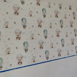 BET-MAR Beata Stępień - Ściana z tapetą w dziecięcym pokoju w Krakowie, wzór w balony i zwierzęta, zabezpieczona niebieską taśmą malarską przy suficie i podłodze. Widoczny fragment gniazdka elektrycznego.