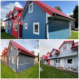 Budscar Budownictwo - Kolorowe domki z czerwonymi dachami po renowacji. Widoczne odcienie niebieskiego i czerwonego. Elewacja drewniana, okna białe. Zadbany trawnik. Słoneczny dzień.