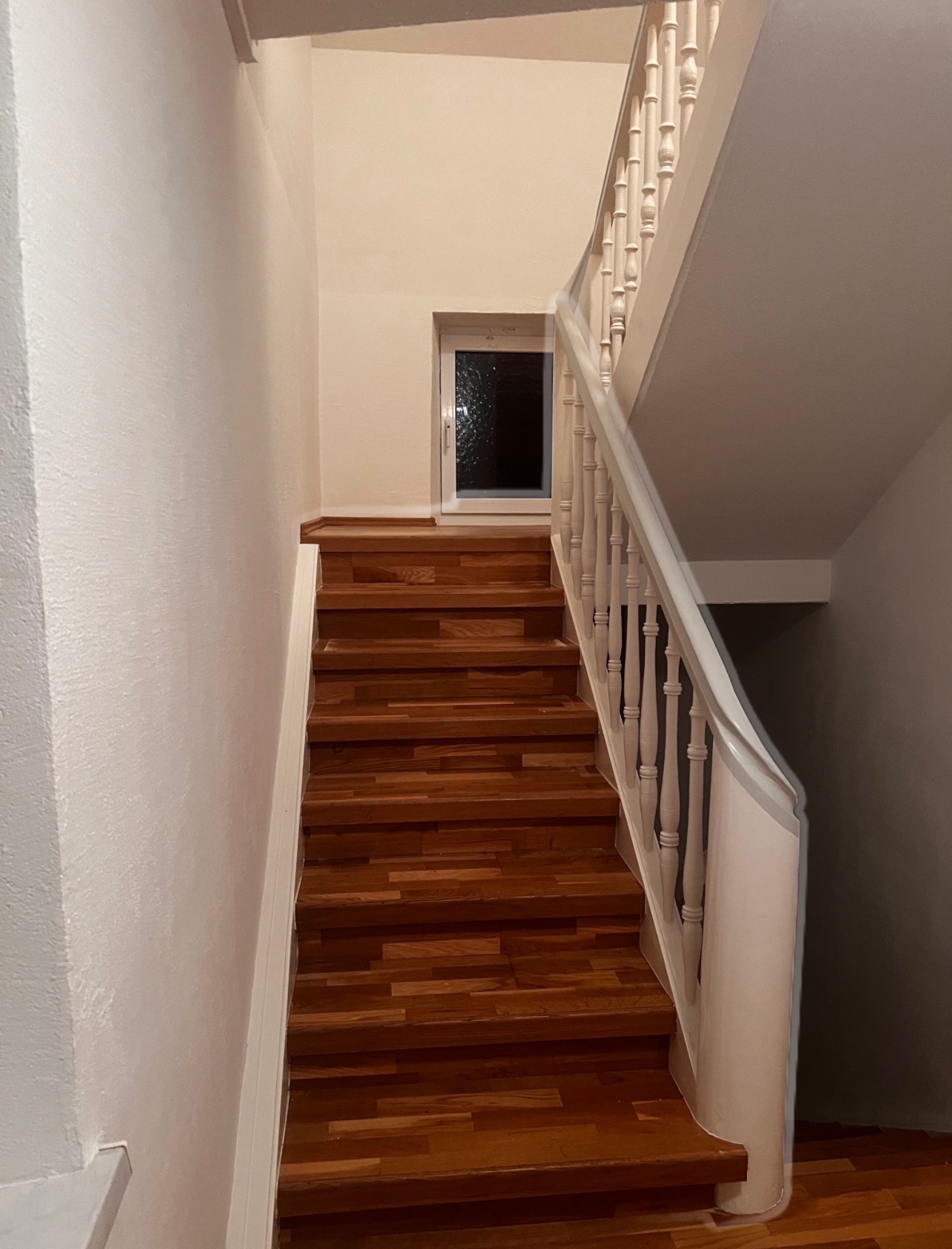 Klatka schodowa po renowacji. Odświeżone ściany, polakierowane schody i poręcz.