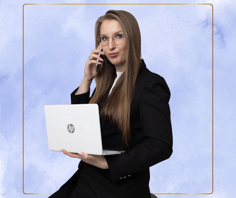 Kobieta w czarnej marynarce, z laptopem i telefonem, na rozmowie biznesowej. Stonowane tło, profesjonalny wizerunek.