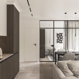 Neuform - Nowoczesne wnętrze: minimalistyczna kuchnia z drewnianymi frontami, szklana ściana oddzielająca sypialnię, szara sofa i stół z krzesłami. Stonowana kolorystyka, eleganckie oświetlenie.