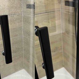 MAT I BŁYSK profesjonalne usługi sprzątania Magdalena Kujawka - Kabina prysznicowa: porównanie stanu przed i po czyszczeniu. Po lewej brudna, po prawej lśniąca, z widoczną czarną ramą i uchwytem. Efekt sprzątania.