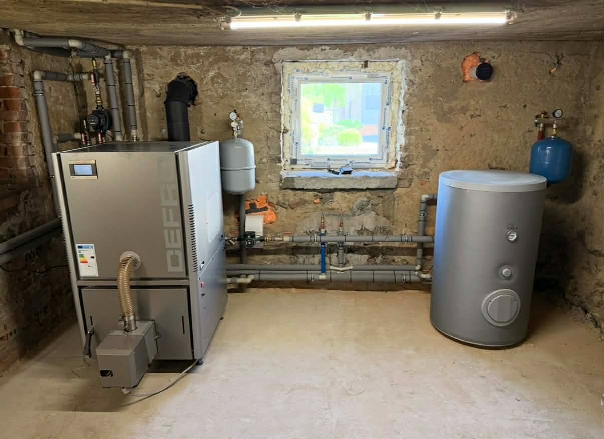 Nowoczesny piec CO Defro i zbiornik buforowy w kotłowni, instalacja hydrauliczna z rur PCV. Usługi hydrauliczne w Kazimierzy Wielkiej.