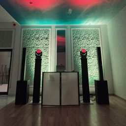 Karol Giżewski Music & Events - Rozstawiony sprzęt nagłośnieniowy i oświetleniowy z DJ-ką na tle dekoracyjnej ściany i sufitu z efektem nieba, gotowy do obsługi imprezy.