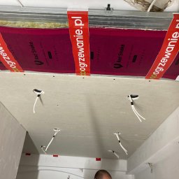 ART-G - Montaż sufitu podwieszanego z płyt karton-gips z widoczną instalacją grzewczą Red Snake i wyprowadzonymi kablami elektrycznymi. Etap prac wykończeniowych.
