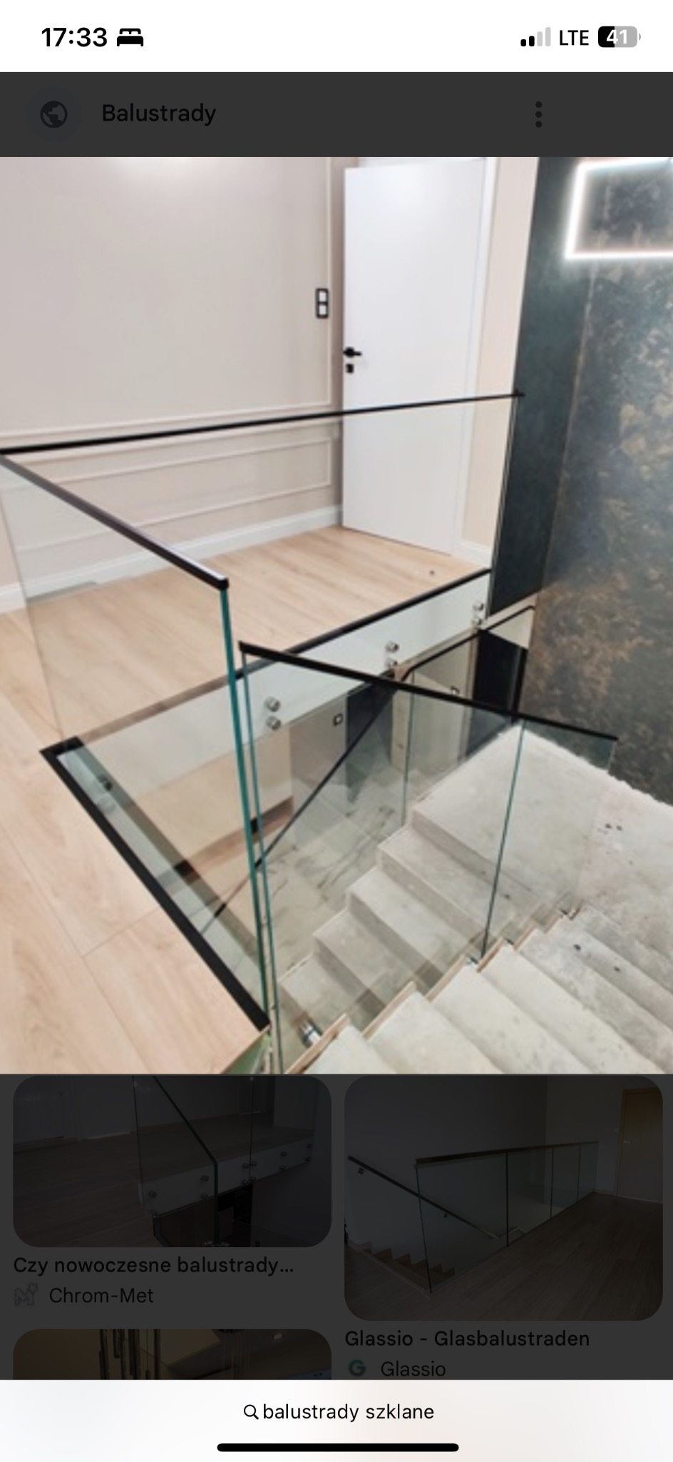 Szklana balustrada schodowa z czarnymi profilami w Mysiadle. Nowoczesny design, jasne wnętrze, drewnopodobne panele podłogowe. Minimalistyczny styl.