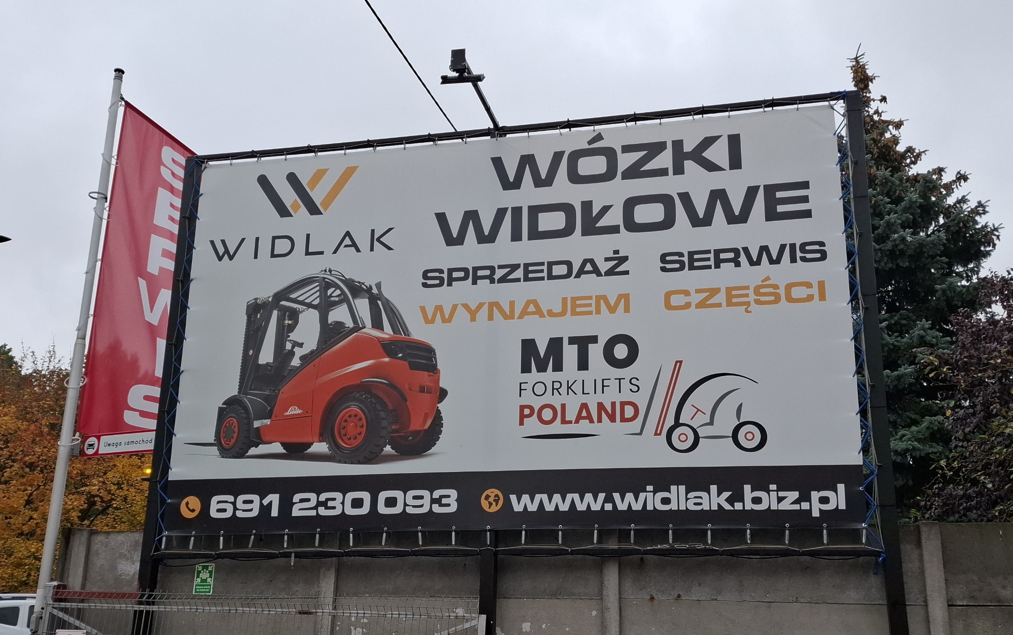 Billboard reklamowy firmy Widlak z wózkiem widłowym Linde, oferującej sprzedaż, serwis, wynajem i części. Widoczne dane kontaktowe i logo firmy MTO Forklifts Poland.