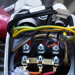 AutomatykaElektrykaDruk3D Zbigniew Obręczarek - Szczegółowe zbliżenie na podłączenia elektryczne wewnątrz metalowej obudowy silnika, widoczne kable w różnych kolorach i złączki, etykieta z oznaczeniem 500W1.
