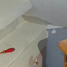 Przedsiębiorstwo Robót Budowlanych ART-DOM Artur Kuk - Wnętrze w trakcie szpachlowania: gładkie, białe ściany schodów, czerwono-żółty śrubokręt leżący na stopniu, widoczne kable elektryczne w ścianie.