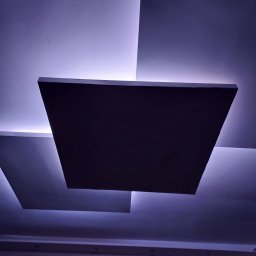 delta remont - Nowoczesny sufit podwieszany z kwadratowymi panelami i subtelnym, fioletowym podświetleniem LED, tworzący unikalny efekt wizualny.