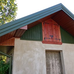 Usługi dekarskie Karol Próchniewicz - Zakończona obróbka blacharska dachu z rynnami w Ulan-Majorat. Widoczna drewniana zabudowa lukarny i zielona blacha. Detal wykończenia.