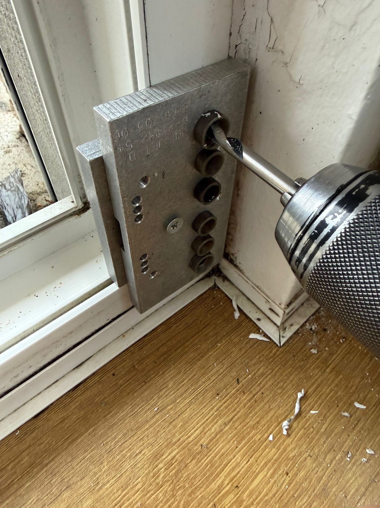 Wiercenie w ramie okiennej przy użyciu szablonu montażowego w Poznaniu. Precyzyjne narzędzie zapewnia dokładność i brak uszkodzeń podczas naprawy.