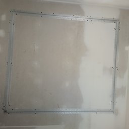 Wikadem Usługi Elektryczne Marcin Jarzyński - Przygotowanie do montażu oświetlenia: metalowa rama na ścianie z widoczną puszką elektryczną. Etap prac przed instalacją lampy.