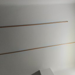 Wikadem Usługi Elektryczne Marcin Jarzyński - Zamontowane szyny oświetleniowe na suficie, widoczne dwie poziome linie i jedna pionowa, minimalistyczny design, szare tło.