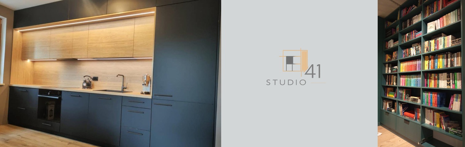 Nowoczesna kuchnia z ciemnymi szafkami i drewnianym blatem, oświetlona listwami LED, obok regał na książki w kolorze butelkowej zieleni. Logo studia projektowego.