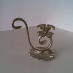 Metalowy, dekoracyjny świecznik z motywem kwiatowym, wykonany z giętego metalu, stojący na białym blacie.
