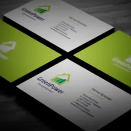 Cztery wizytówki firmy GreenPower ułożone na ciemnym, drewnianym tle pod kątem, z widocznym logo w kolorze zielonym i danymi kontaktowymi.