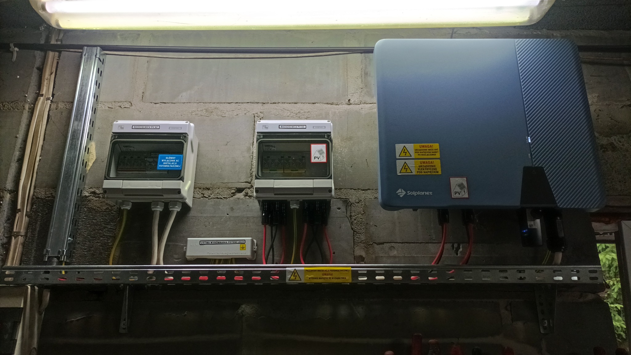 Rozdzielnice PV AC/DC i falownik Solplanet, instalacja w Krupnikach (Białystok). Widoczne przewody i oznaczenia ostrzegawcze. Elementy systemu fotowoltaicznego.