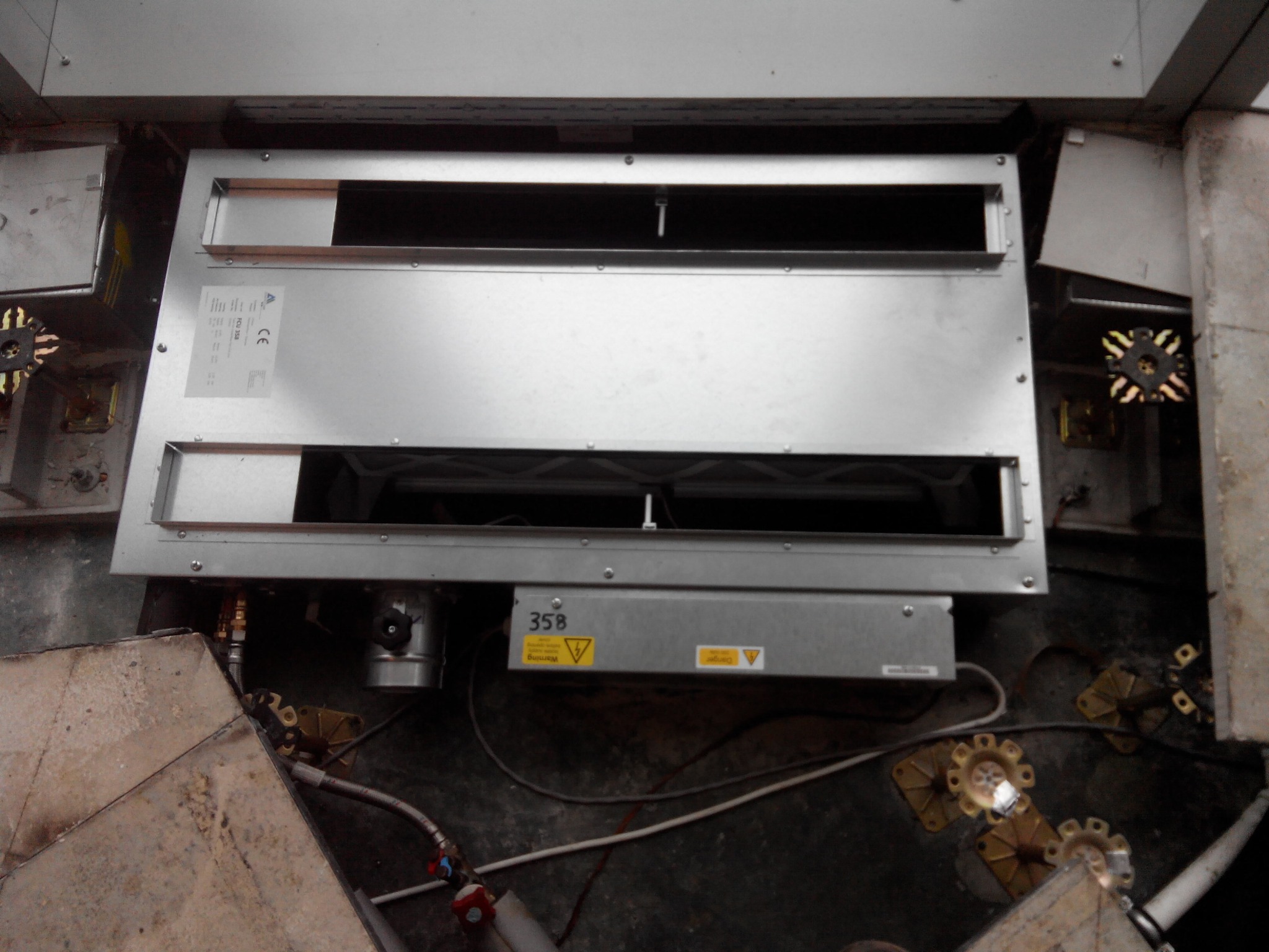 Metalowa obudowa z otworami i oznaczeniem 35B, prawdopodobnie element instalacji grzewczej, widoczna instalacja podłączeniowa i elementy montażowe.