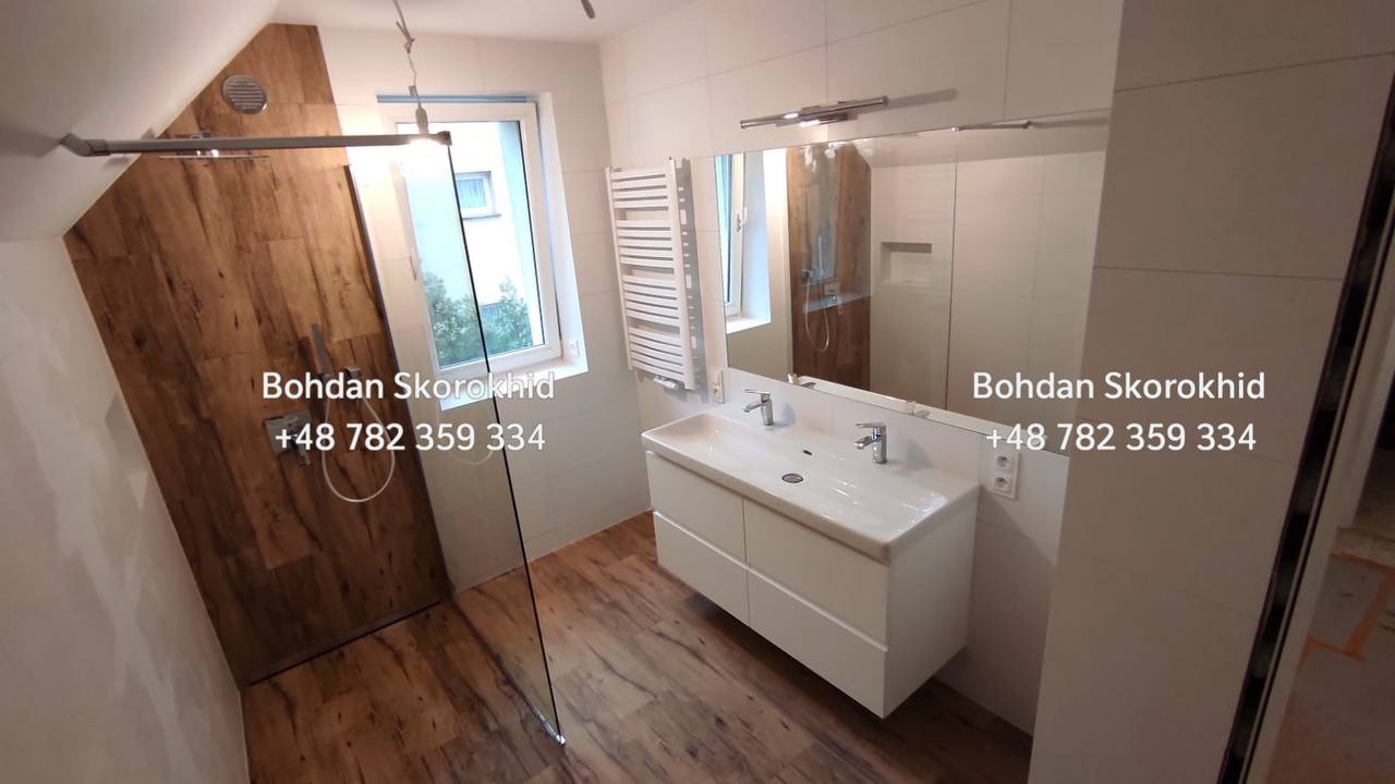 Nowoczesna łazienka na poddaszu w Szczawnie-Zdroju z kabiną prysznicową wykończoną drewnopodobnymi panelami i białą szafką z umywalką.