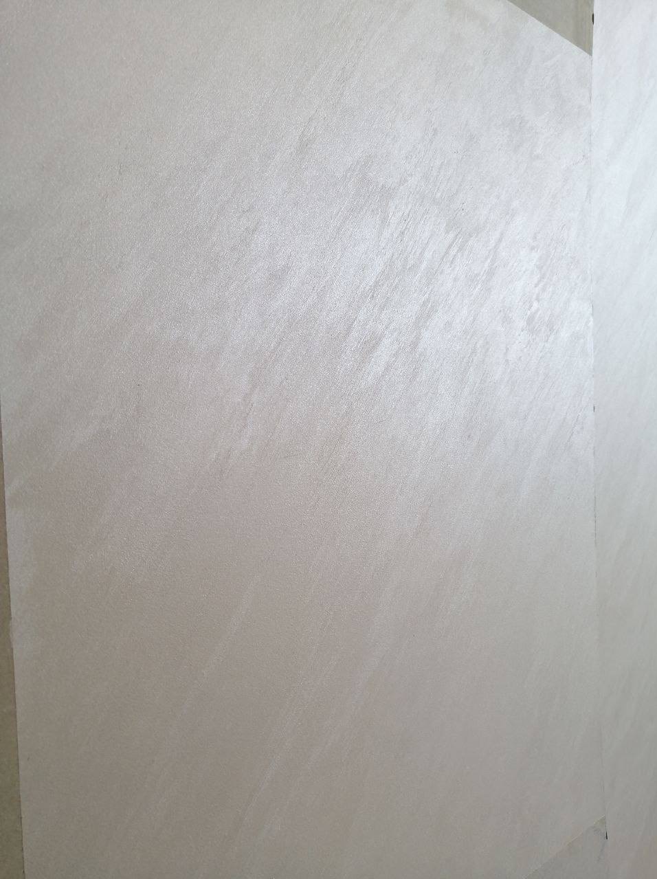 Ściana pokryta dekoracyjną, srebrzystą farbą z subtelnym, diagonalnym wzorem. Widoczny fragment narożnika. Delikatny połysk podkreśla fakturę.