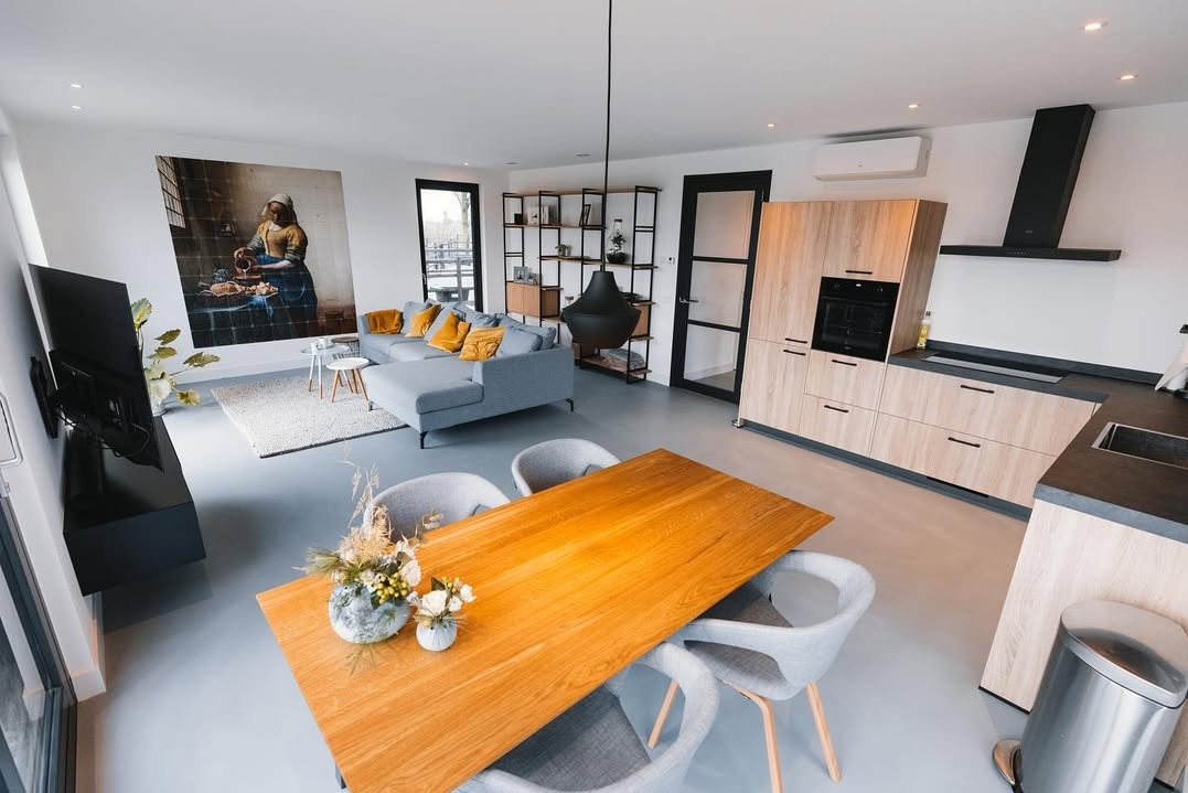 Jasnoszara posadzka w nowoczesnym salonie z drewnianym stołem, szarą sofą i obrazem na ścianie. Minimalistyczny design, neutralna kolorystyka, widok z góry.