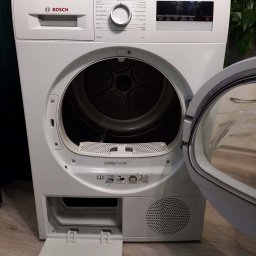 Burklin Marcin Burak - Otwarta suszarka Bosch Serie 4, widoczne wnętrze bębna i filtr. Panel sterowania z programami prania. Dolna klapka otwarta, ukazująca filtr. Ujęcie z bliska.