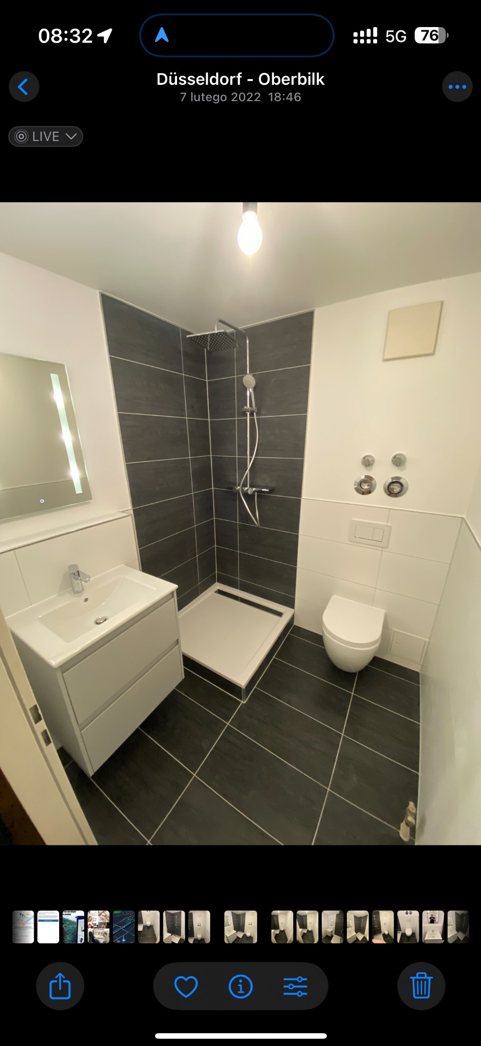 Nowoczesna łazienka po remoncie: czarne płytki podłogowe i ścienne, biała armatura (umywalka, toaleta, brodzik), minimalistyczny design, oświetlenie sufitowe.