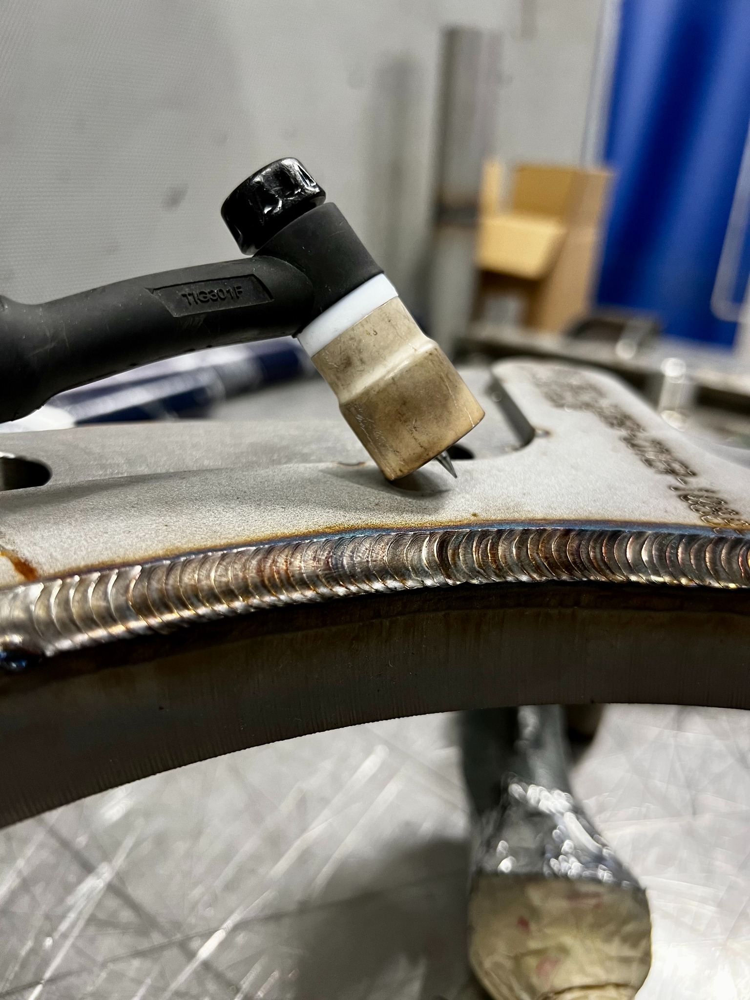 Precyzyjne spawy TIG na metalowym elemencie, widoczne regularne ściegi spawalnicze. Detal z bliska, ukazujący jakość wykonania i estetykę połączenia.