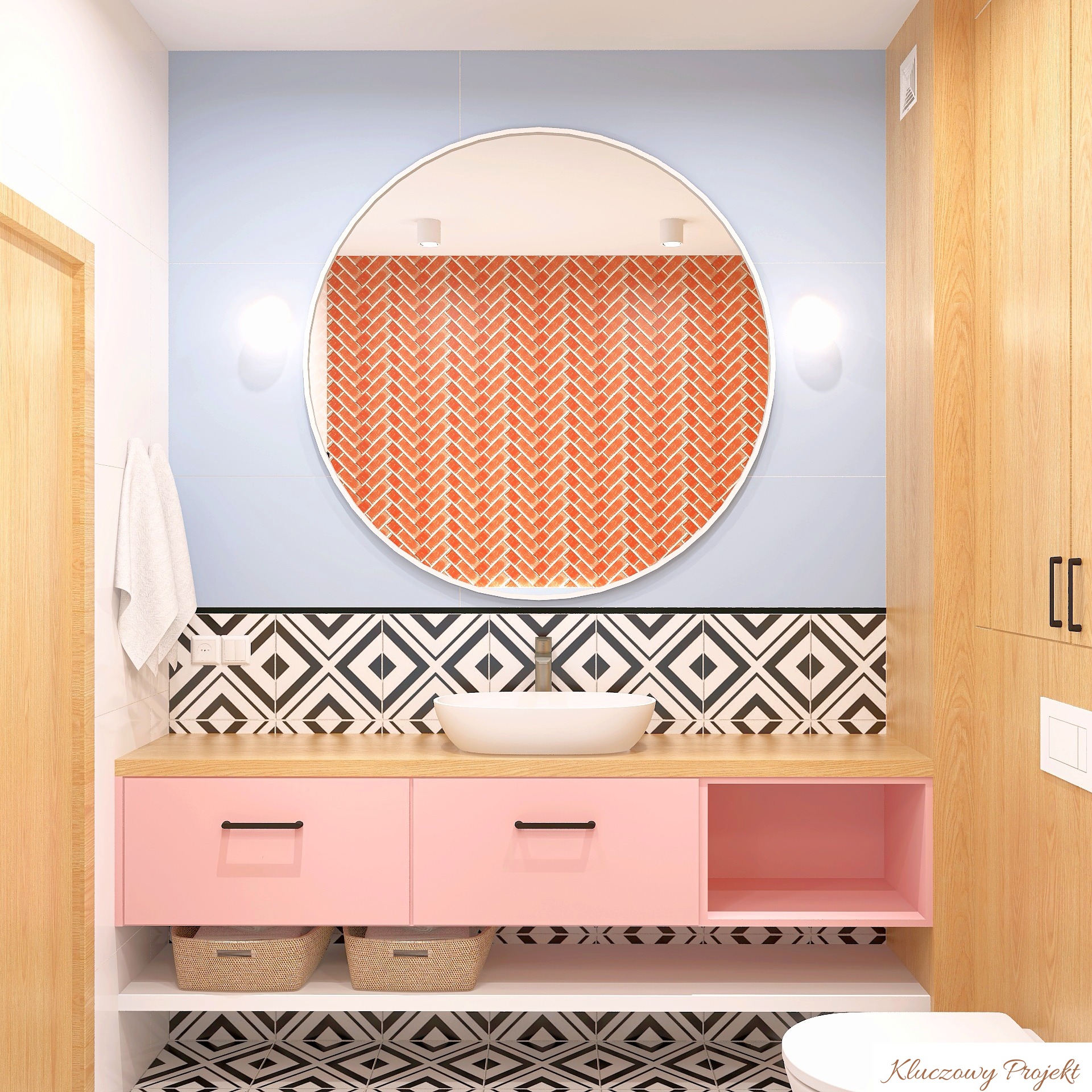 Nowoczesna łazienka z okrągłym lustrem, różową szafką pod umywalką i wzorzystymi płytkami. Widoczne oświetlenie i drewniane elementy wykończenia.